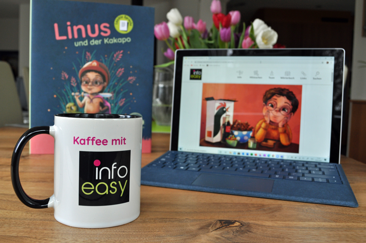 Eine Tasse mit dem Logo von infoeasy, darüber steht Kaffee mit. Hinter der Tasse ist das Buch mit dem Titel Linus und der Kakapo und ein aufgeklapptes Laptop