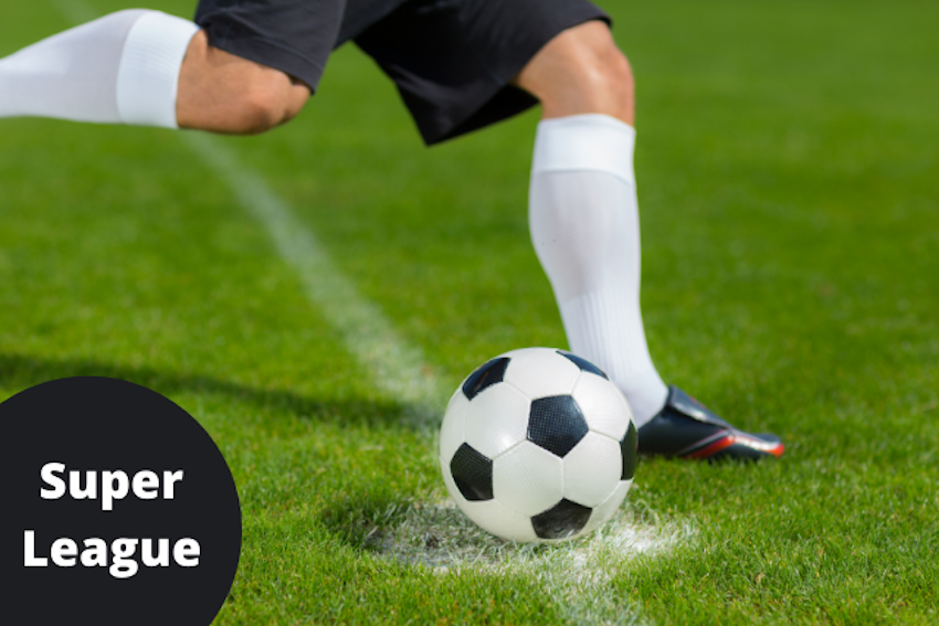 Auf der Mitte eines Fussball-Spielfeldes steht der Ball bereit zum Spiel. Ein Fussballer hebt sein rechtes Bein, um den Ball zu spielen. In der linken Ecke des Bildes steht in einem schwarzen Kreis in weisser Schrift: Super League.