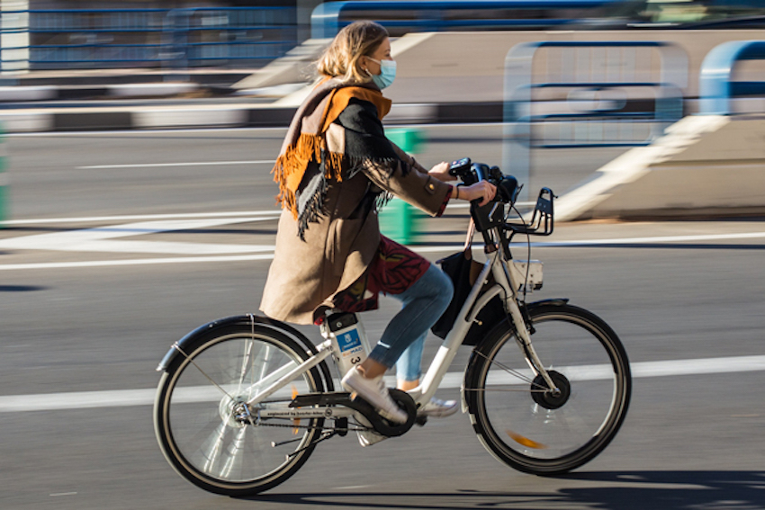 Eine Frau fährt auf einem E-Bike. Sie trägt keinen Helm.