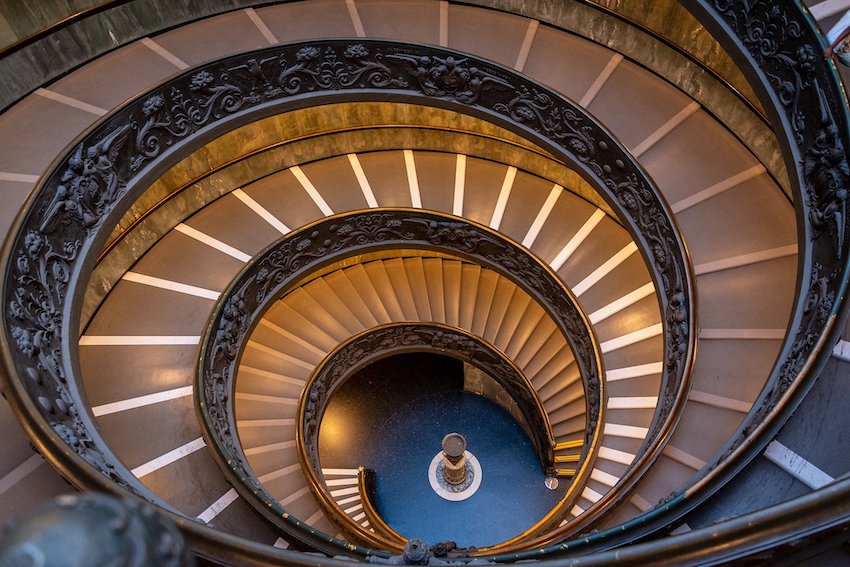 Eine grosse Wendeltreppe mit reich verziertem Gel&auml;nder in einem Geb&auml;ude im Vatikan in Rom.