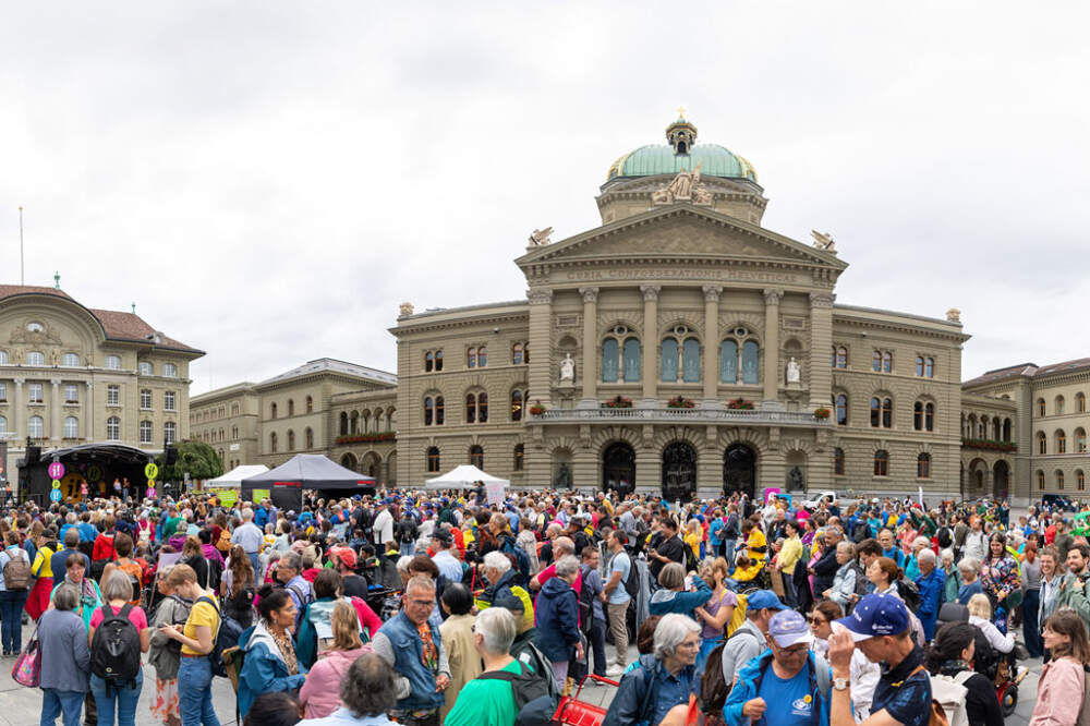 Vor dem Bundeshaus stehen viele Menschen mit und ohne Behinderung.