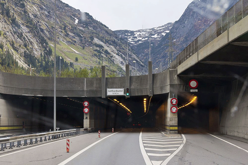 Nordportal des Gotthard-Tunnels. Die Ampel steht auf gr&uuml;n. Im Tunnel verschwindet eine Auto, es sind nur noch die R&uuml;cklichter zu sehen. Vor dem Tunnel ist die Strasse frei.
