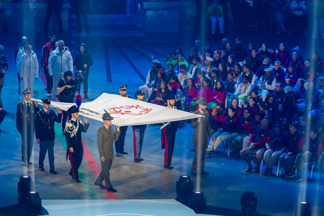 Die Sportler tragen die olympische Flagge ins Stadion.