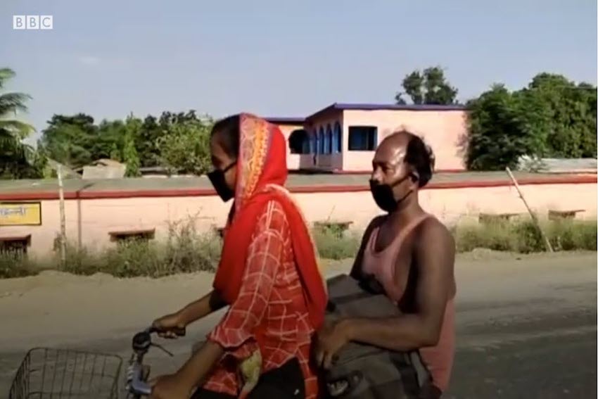 Die 15-jährige Jyoti Kumari fährt vorne auf dem Velo. Ihr Vater sitzt hinter ihr auf dem Gepäckträger und hält eine Tasche auf seinen Knien fest.