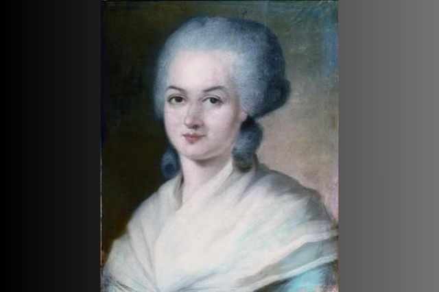 Ein gemaltes Portr&auml;tbild von Olympe de Gouges. Sie tr&auml;gt eine Hochsteckfrisur, die mit grauem Puder bedeckt ist. Ein Schultertuch bedeckt die Schultern.