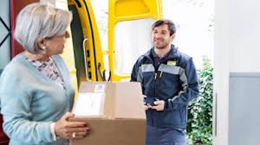Ein Postbeamter hat einer Frau ein Paket gebracht.