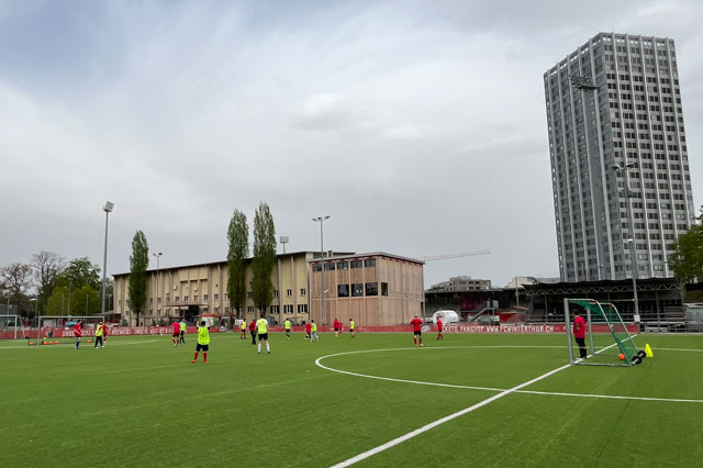 Das Bild zeigt eine Trainingszene auf den Fussballplatz. Zwei Teams stehen spielen gegeneinander.