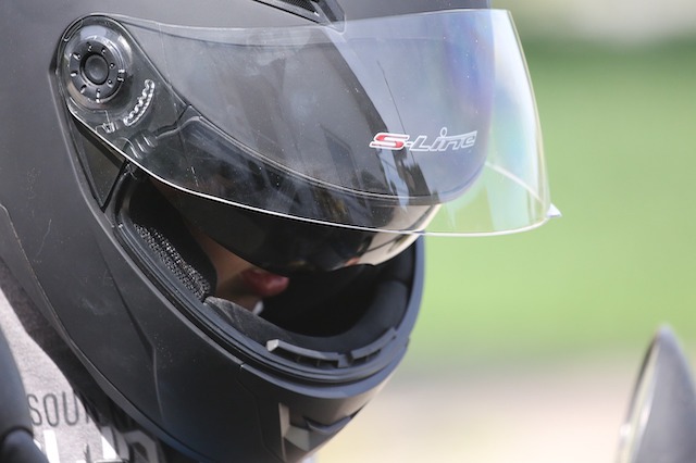 Ein Motorradfahrer tr&auml;gt einen Helm mit einem Visier.