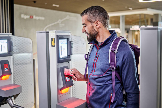 Ein Mann l&auml;dt am Automaten seinen Swisspass auf.