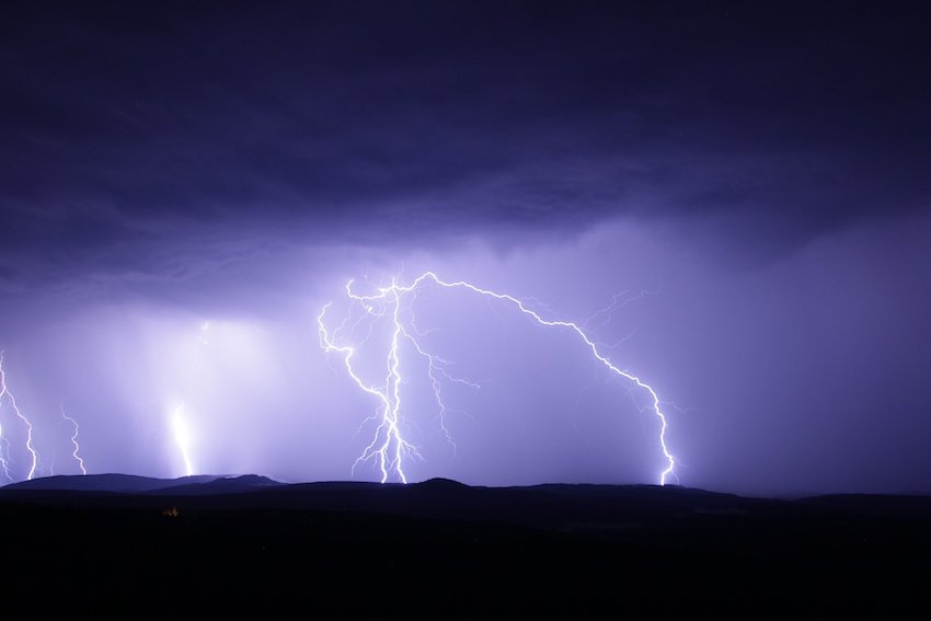 Blitze erhellen den Himmel bei Nacht.
